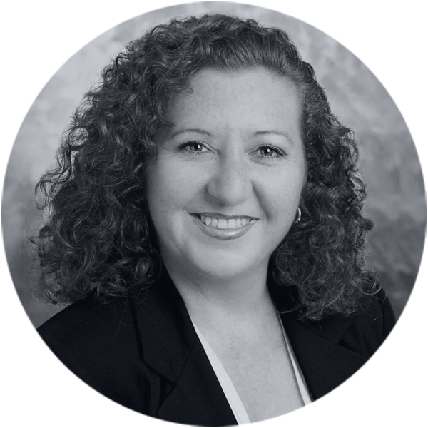 Confident Woman Professional Portrait Black and White Smiling woman with curly hair in a business blazer, black and white professional headshot.